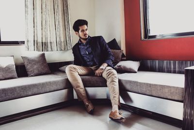 Young man sitting on sofa at home