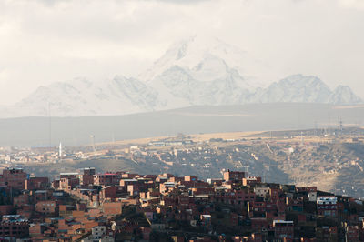 Aerial view of town and mountains against sky