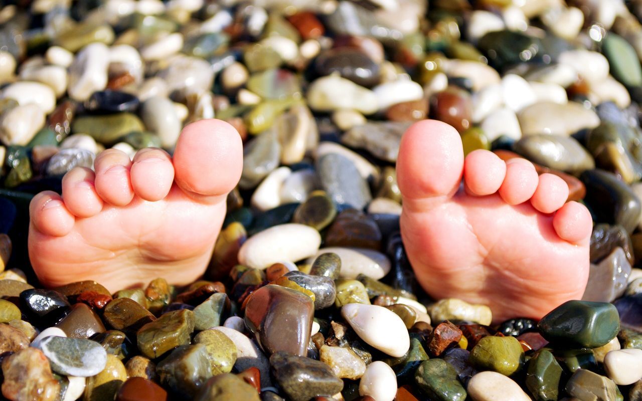 person, beach, part of, close-up, high angle view, pebble, lifestyles, human finger, barefoot, seashell, leisure activity, holding, stone - object, unrecognizable person, day, focus on foreground