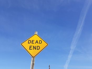 Road sign against blue sky