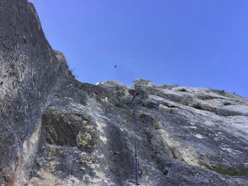 Low angle view of rock formations against clear blue sky