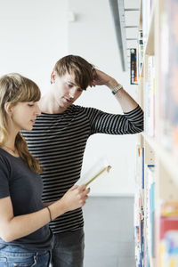 Young students reading book in college library