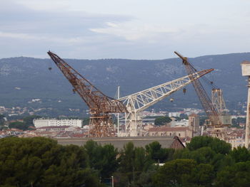 Cranes at construction site against sky