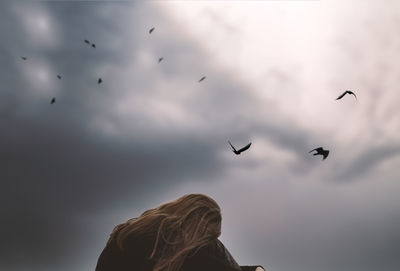 Low angle view of bird flying against sky