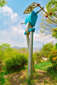 Trees on landscape against cloudy sky