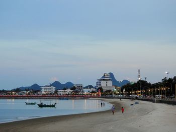 People on beach against blue sky