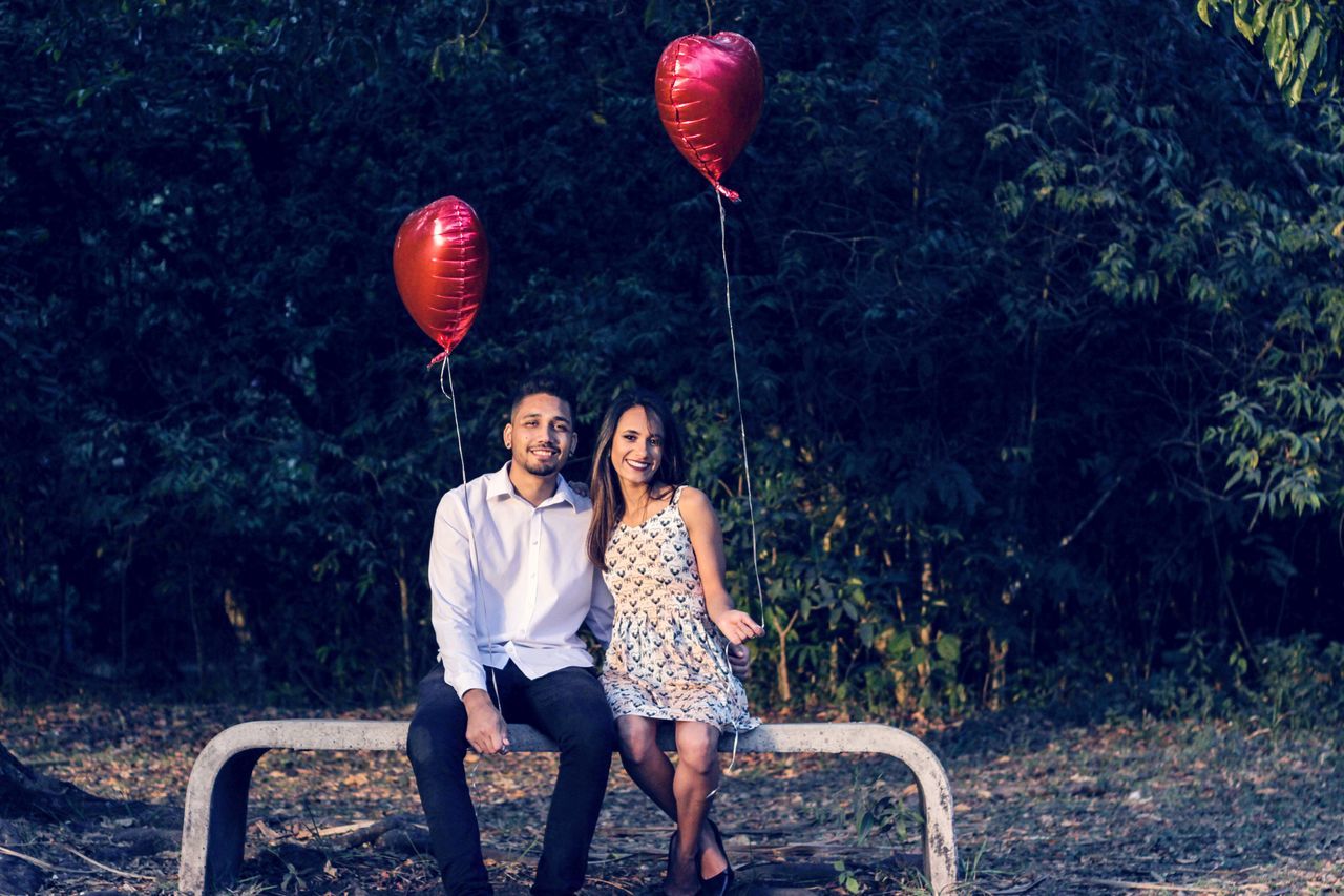 two people, togetherness, emotion, young adult, positive emotion, love, balloon, young women, women, leisure activity, people, men, real people, nature, bonding, happiness, young men, couple - relationship, tree, plant, outdoors