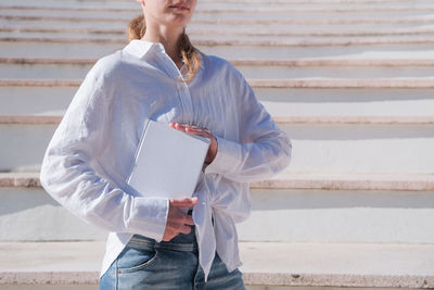 Young woman standing against wall
