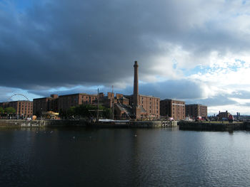 River by buildings against sky in city