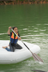 Full length of boy on boat in lake