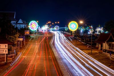 High angle view of light trails on road and naresuan bridge at night