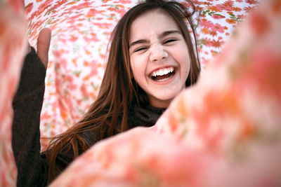 Portrait of happy girl amidst fabric