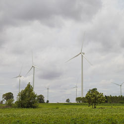 Windmills on field against sky