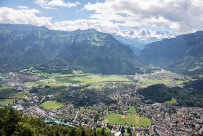 Aerial view of townscape and mountains against sky