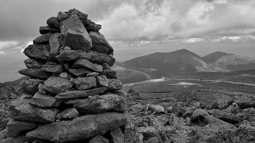 Stack of rocks on landscape against sky