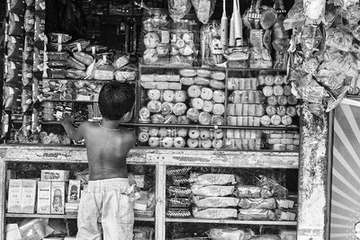 Boy standing at market stall for sale