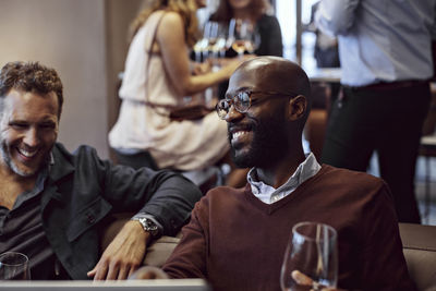 Happy coworkers enjoying drinks after work during office party