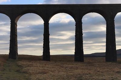 Arch bridge against sky during sunset