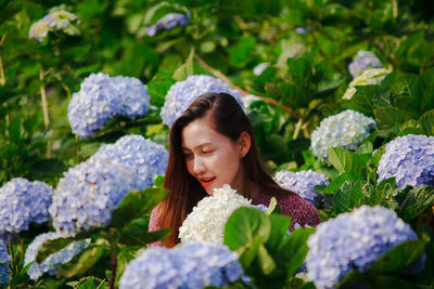 Portrait of woman against purple flowering plants