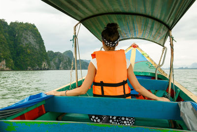 Young woman on the long-tail boat during her vacations in thailand