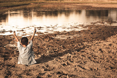 Rear view of man standing at lakeshore