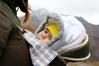 Midsection of woman standing with baby on mountains