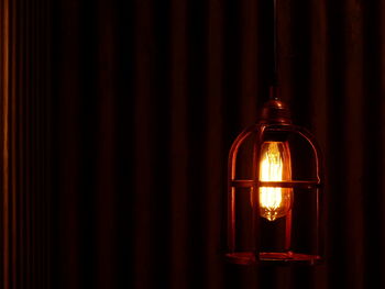 Close-up of illuminated lantern against railing at night