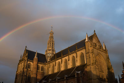 Low angle view of cathedral against rainbow in sky