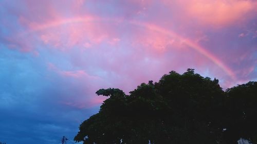 Low angle view of rainbow against sky during sunset