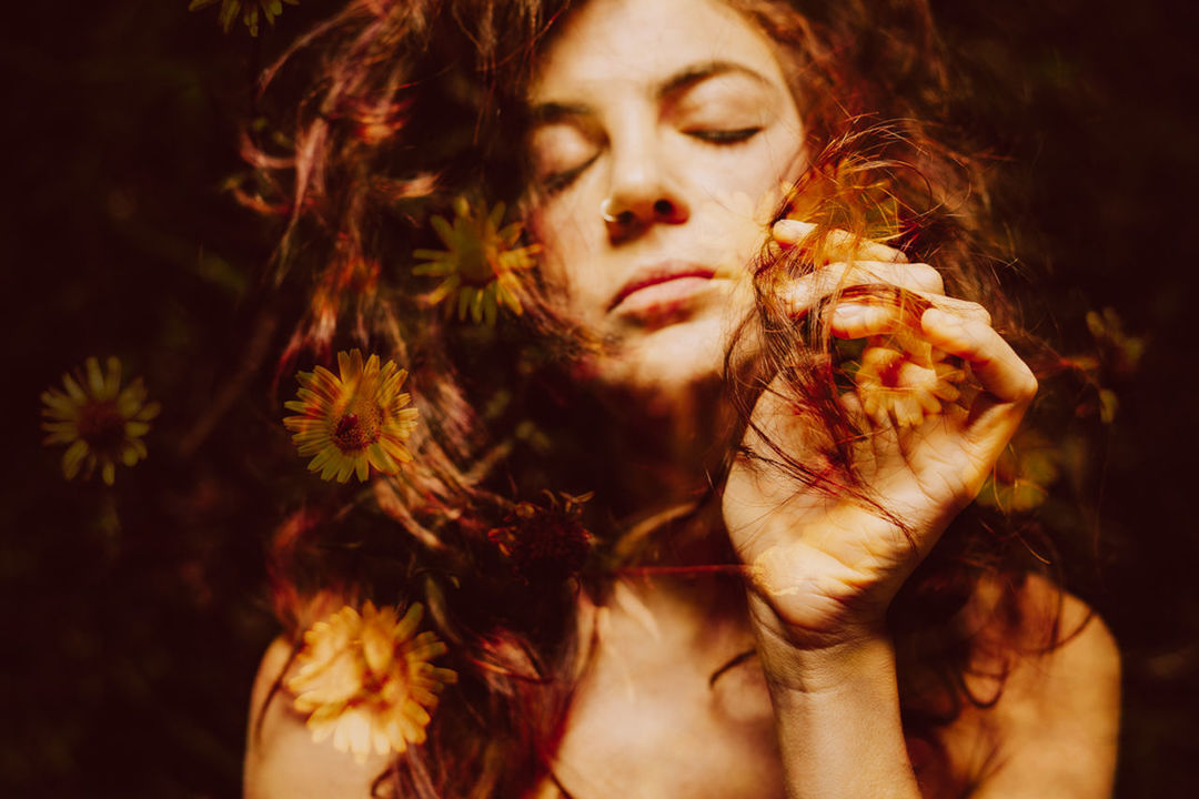 CLOSE-UP PORTRAIT OF YOUNG WOMAN HOLDING HAIR