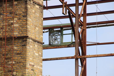 Low angle view of hanging from window against sky