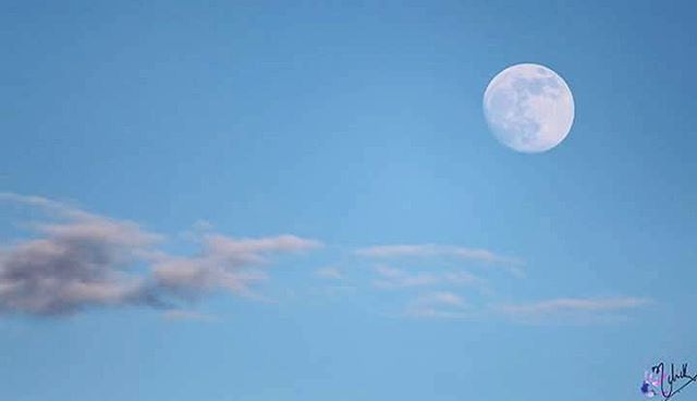 moon, low angle view, sky, blue, beauty in nature, copy space, scenics, tranquility, nature, astronomy, tranquil scene, circle, clear sky, mid-air, full moon, planetary moon, sphere, outdoors, space exploration, cloud - sky