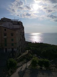 Scenic view of sea by buildings against sky