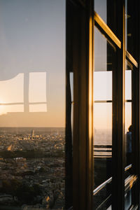 Buildings seen through window during sunset