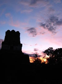 Low angle view of silhouette trees against sky at sunset