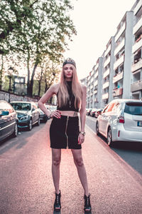 Full length of young woman standing on road in city