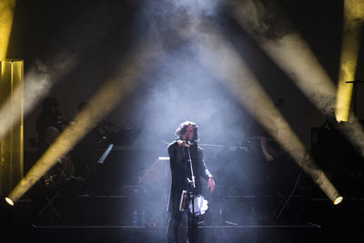 Man standing in illuminated stage