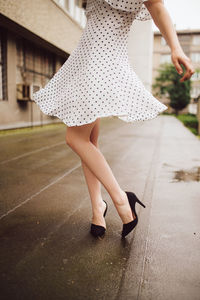 Low section of woman walking on street