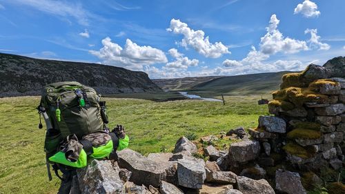 Rear view of man standing on mountain against sky