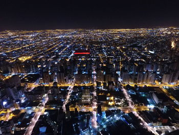 Aerial view of illuminated cityscape against sky at night