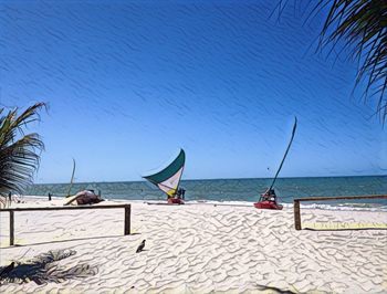 Scenic view of beach against clear blue sky