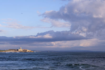 Scenic view of sea by buildings against sky