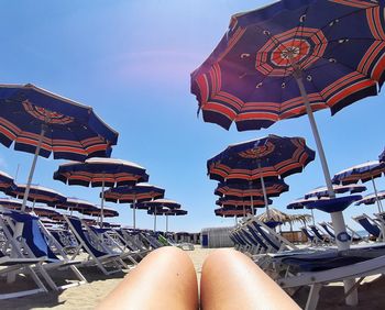 Low section of woman relaxing against sky