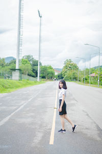 Full length of woman on road against sky