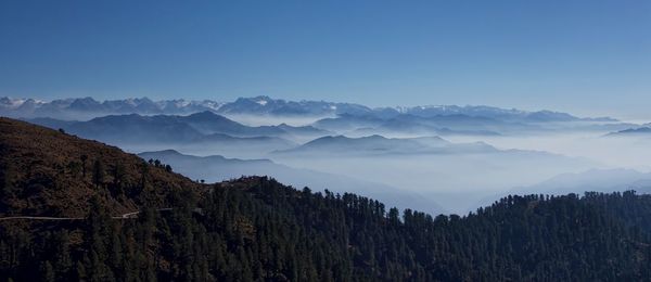 Scenic view of mountains against blue sky