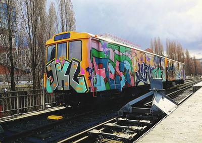 Graffiti on train against sky