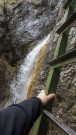 Low section of person against waterfall