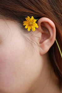 Close-up of woman with pink flower