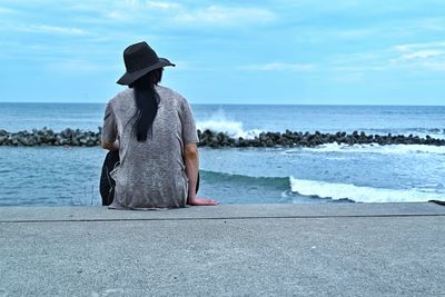 Looking at the sea, my hair is long, but i'm a man