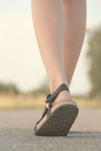 Low section of woman wearing high heels standing outdoors